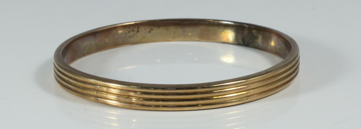 A 10ct gold reeded, stiff bangle, gross weight approximately 16.0g