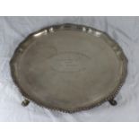 A large silver salver with gadrooned pie-crust rim, raised on four hoof feet, London, 1927, engraved