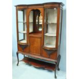 An Edwardian inlaid mahogany display cabinet, the central open section with mirrored back, above a
