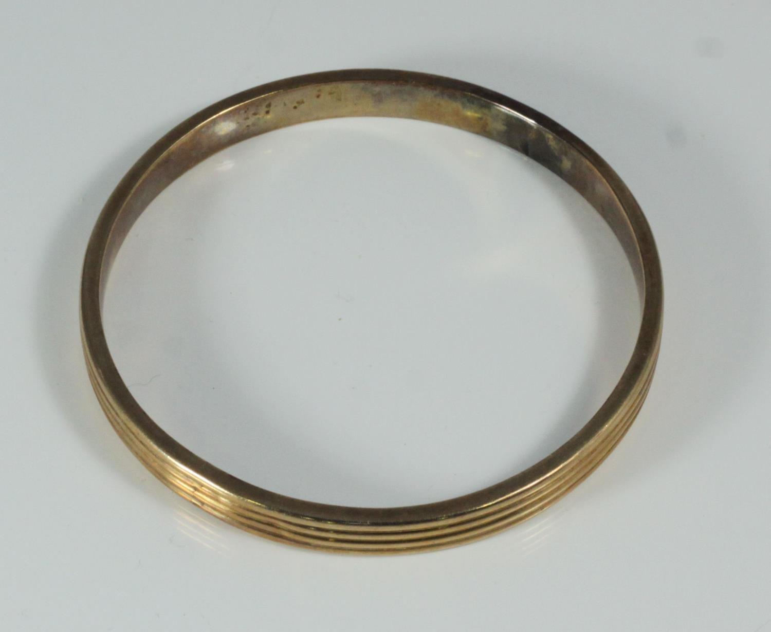 A 10ct gold reeded, stiff bangle, gross weight approximately 16.0g - Image 2 of 2