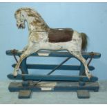 A white painted wooden rocking horse, with padded leather saddle, metal rockers and supported on