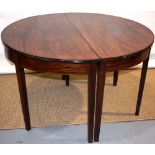 A George III mahogany sectional dining table, a pair of half round ends to the reeded edge top to