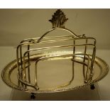 An early George III silver oval toast rack, the oval tray with a vitruvian scroll engraved border,