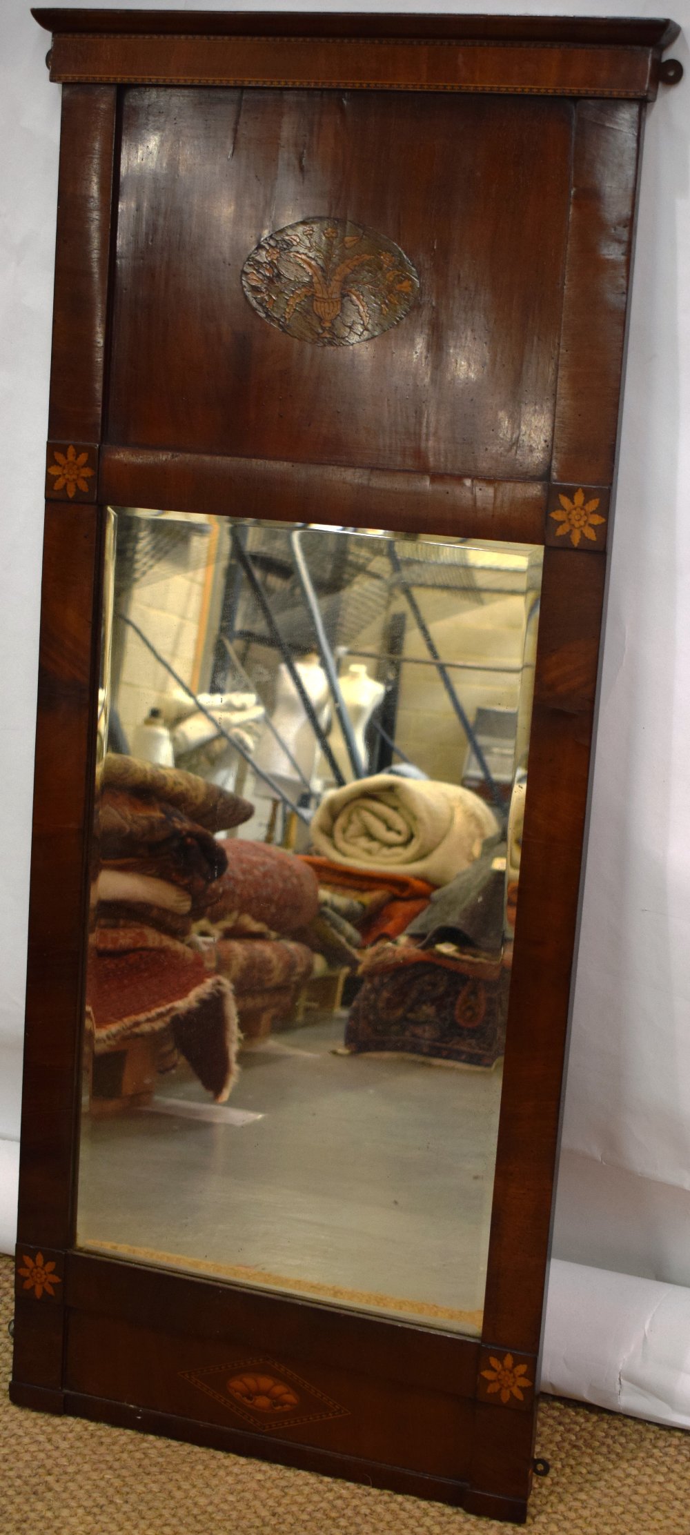 A Channel Islands mahogany veneered pier mirror, the cornice with inlay above a figured panel with