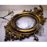 A Regency giltwood frame convex mirror, surmounted by a carved hippocampus and sprays of foliage,