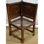 An unusual eighteenth century ash vernacular corner chair, with fielded panels, a plaited seat, on