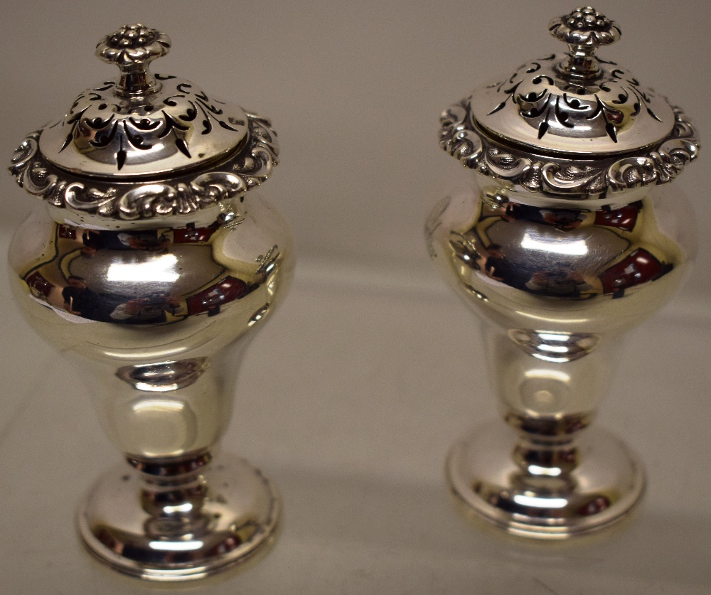 A pair of early Victorian silver peppers, the inverted pear shape bodies with foliage scroll