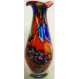 A Murano millefiore glass vase, with red and coloured marbling, a triform rim, on a circular foot,
