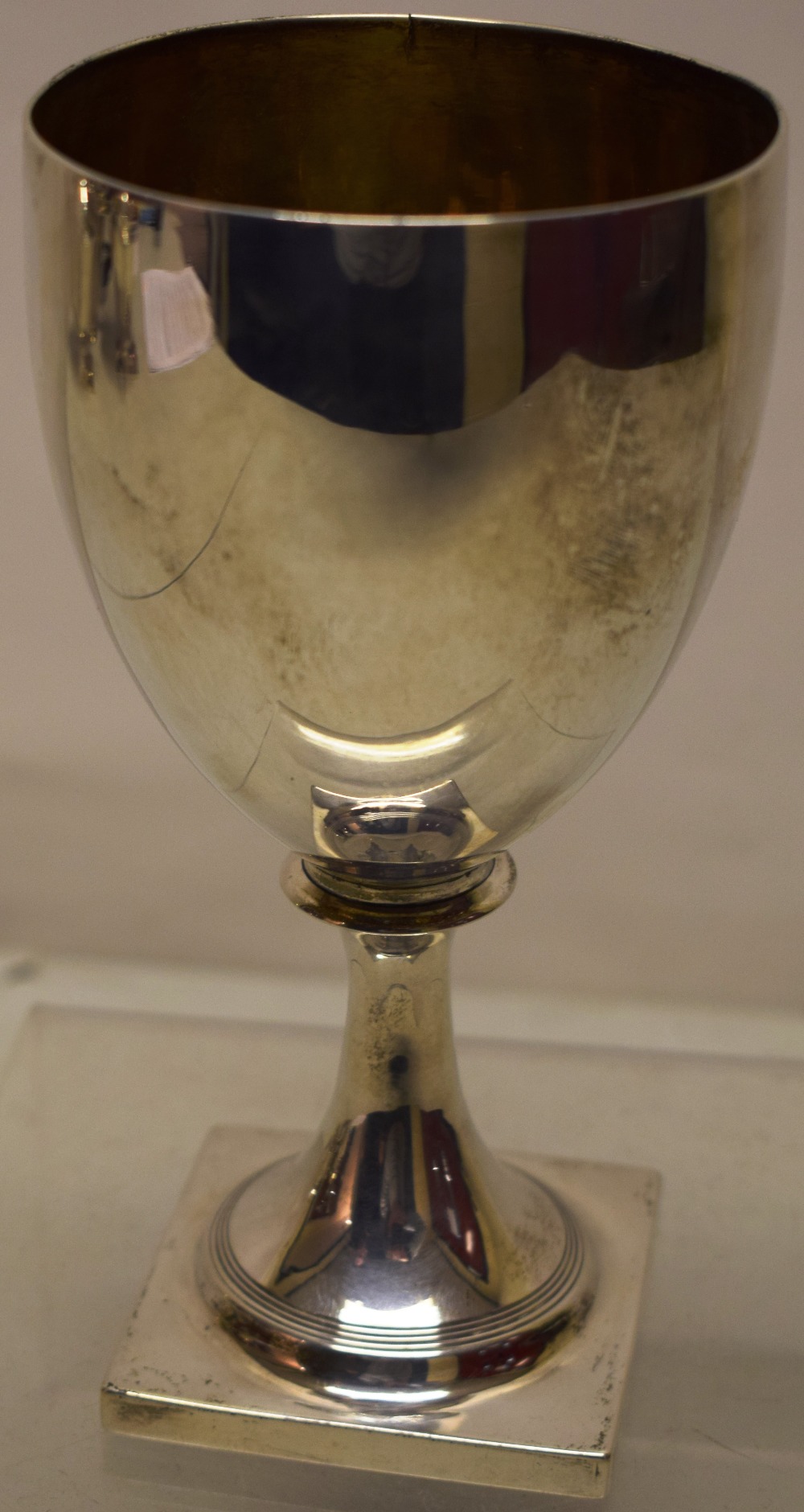 A George III silver wine goblet, the ovoid bowl with a gilded interior, the stem foot on a square