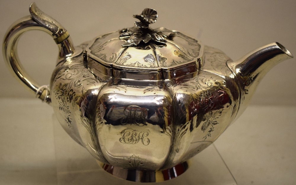 An early Victorian melon panelled circular teapot, with chased decorated sides with initials, a