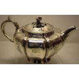An early Victorian melon panelled circular teapot, with chased decorated sides with initials, a