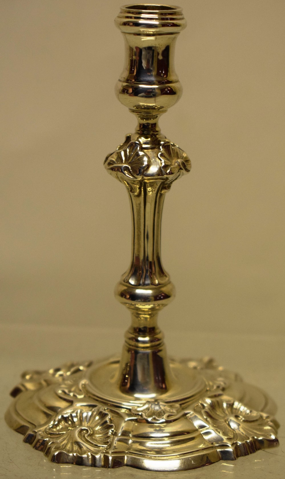 An early Victorian cast rococo revival silver taperstick, in the manner of Paul De Lamerie, with