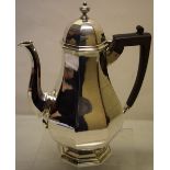 A George V silver octagonal coffee pot, the pear shape body with a facetted swan neck spout, domed