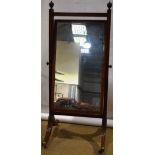 A Regency mahogany cheval mirror, the rectangular swing glass in a reeded stretchered frame, with