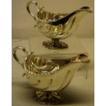 A pair of late Victorian silver oval sauceboats, with shell fluted bowls engraved a stags head