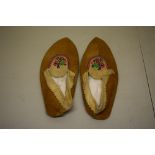 Pair of ladies buckskin mocassins, with turned over edges, 11in. long X 4 3/4in. Wide x 2 3/4in.
