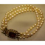 A vintage cultured pearl three strand bracelet, approx 7in (18cm) the pierced back, gold snap set, a