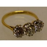 A three stone diamond ring, in a gold coloured metal claw setting, probably early twentieth century,