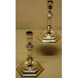 A pair of George 1st cast silver candlesticks, the urn shape candleholders with a girdle moulding,