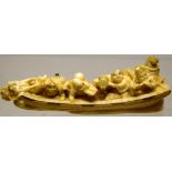 A Japanese late nineteenth century carved ivory dragon boat netsuke, of musicians and muses