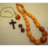 A reconstituted amber necklace, approximately 60gm, an amber set cross in white metal .925, a pair