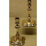 A pair of George II cast silver candlesticks, the knopped panelled stems with moulded shoulders, the
