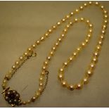 A vintage cultured pearl necklace, 17in (43cm) the pierced back gold snap set with a garnet and