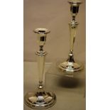 A pair of silver circular candlesticks, the octagonal panelled urn shape candleholders, with