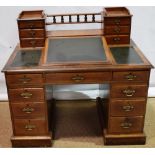 A Victorian oak 'Dickens' desk, with bollarded oak veneered borders, the top with a writing slope,