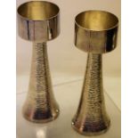 A pair of modern silver designer candlesticks, the tub shape holders, on bark effect tapering stems,