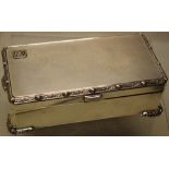 A silver rectangular cigarette box, engine turned with chased Celtic borders, a tablet thumbpiece,