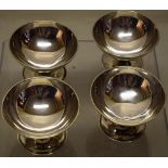 A set of four George III silver circular salts, the crested shallow bowls with reeded rims on