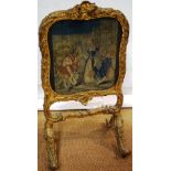 A William IV early Victorian gilt gesso frame rococo revival firescreen, with a Berllin woolwork