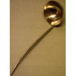 A modern designer silver punch ladle, the hammered circular bowl with a cast bark effect handle, 9in