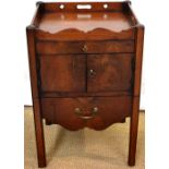 A George III mahogany bedside cupboard, the pierced fretwork gallery top above a pair of cupboard