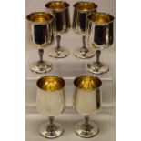 A set of six modern designer silver wine goblets, the bowls gilded inside, on writhen bark effect