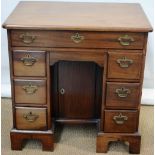 A George II Cuban faded mahogany kneehole desk, the caddy moulded edge top above a frieze drawer and