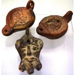 Three Ancient Roman pottery table oil lamps, in the form of a Satyr mask, 4.5in (11.5cm) Aurora on a