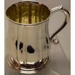 A George II silver pint tankard, the panelled baluster body with a capped hollow scroll handle, on a