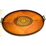 A George III oval tray, veneered in sections of satinwood, the centre inlaid an oval plumed