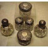 A late Victorian six piece toilet bottle suite the moulded glass bodies, with chased silver mount,
