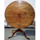 A mid eighteenth century faded mahogany occasional table, the circular tilt top on a plain turned