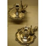 A pair of Victorian silver bedroom chamber candlesticks, with moulded shell scroll border bases,