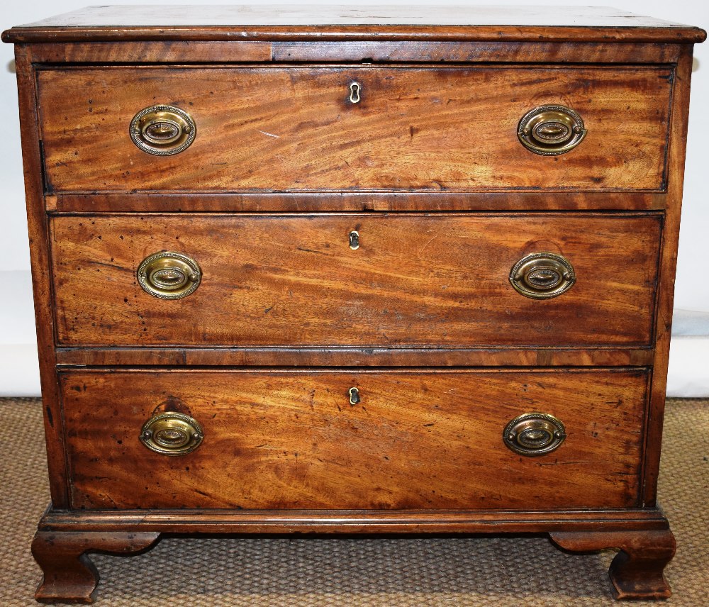 A small late eighteenth century faded mahogany dressing commode, the crossbanded top above three