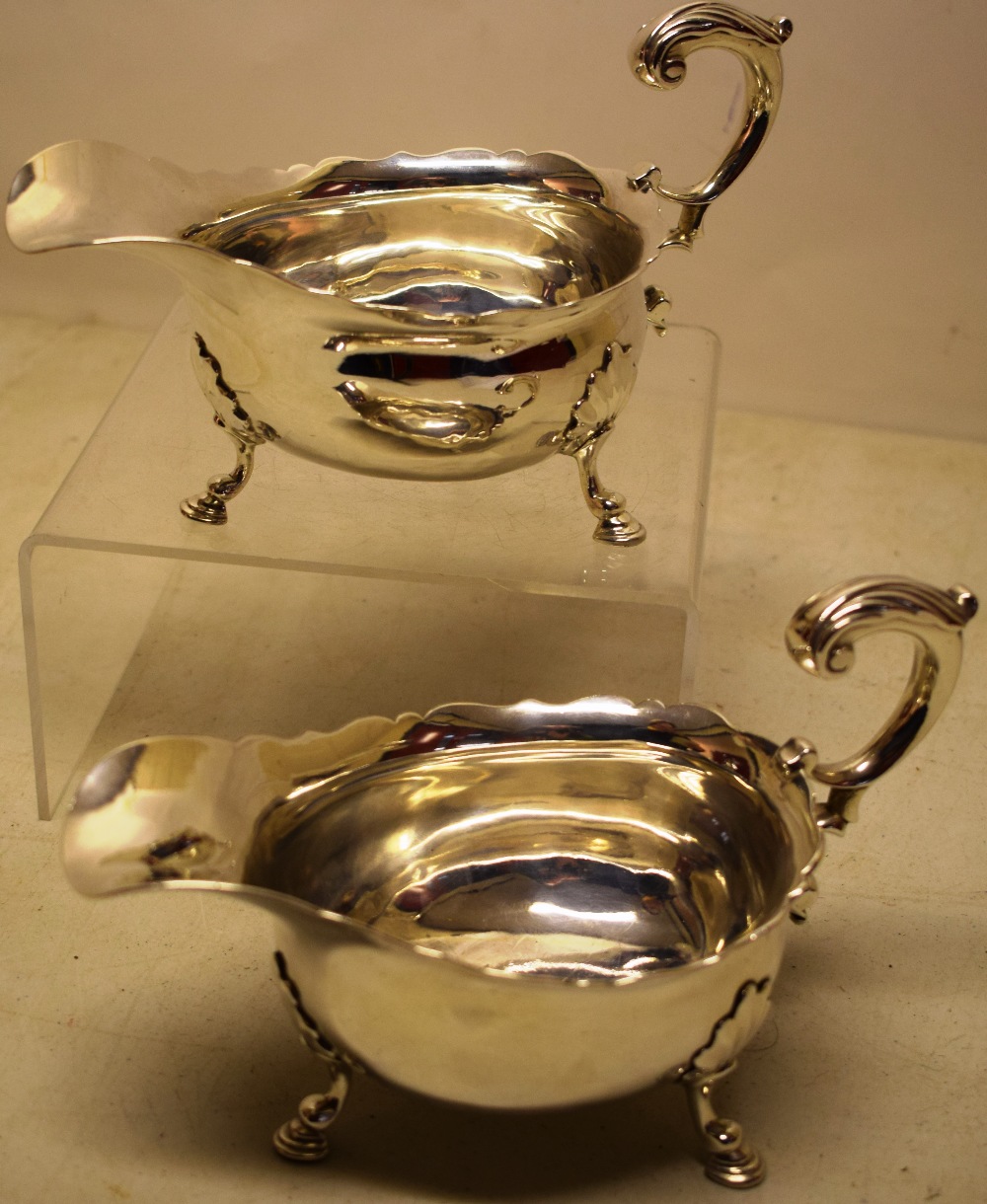 A pair of George II silver sauceboats, with fretwork borders, cast leaf capped scroll handles, one