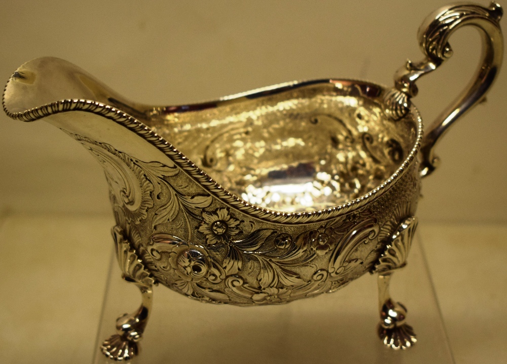 A large George IV silver sauceboat, the sides with contemporary chased and repousse foliage, with