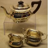 A silver three piece tea service, with ovoid ogee bodies, having incurved corners to the rims, the