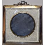 An Edwardian photograph frame, the back covered in ivory coloured floral material, having a bevelled