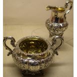 An early Victorian Irish silver milk jug and sugar basin, the panelled sides with repousse foliage