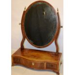 A Sheraton mahogany veneered oval swing toilet mirror, inlaid stringing, with scroll side